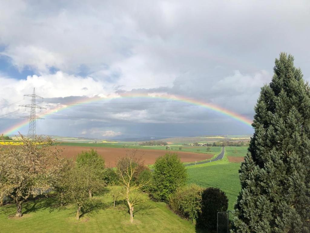 un arco iris en el cielo sobre un campo en Ferienwohnung auf dem Maifeld, en Gappenach