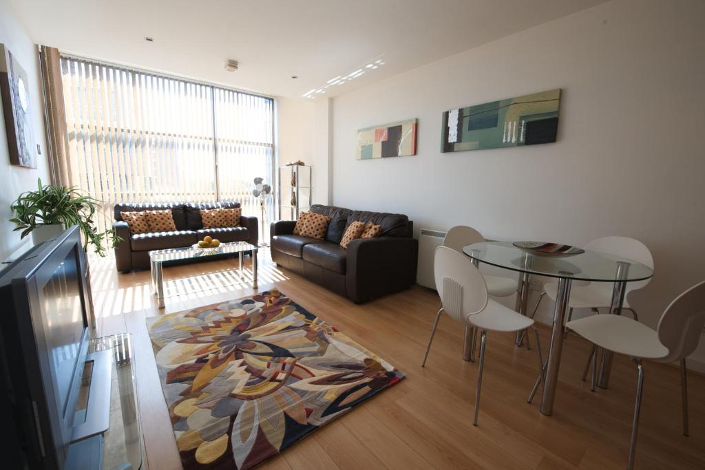 a living room with a couch and a table at Stay Deansgate Apartments for 14 nights plus in Manchester