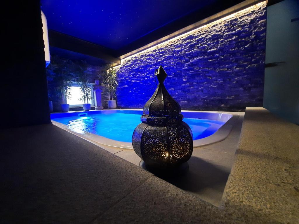 a vase sitting next to a swimming pool at night at Le Clos des Thermes Suites de Luxe avec wellness privatif in Chaudfontaine