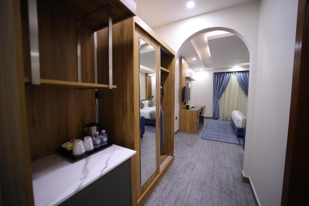 uma casa de banho com um quarto com uma cama e um espelho em PRIMOTEL Elite As Salamah em Jeddah