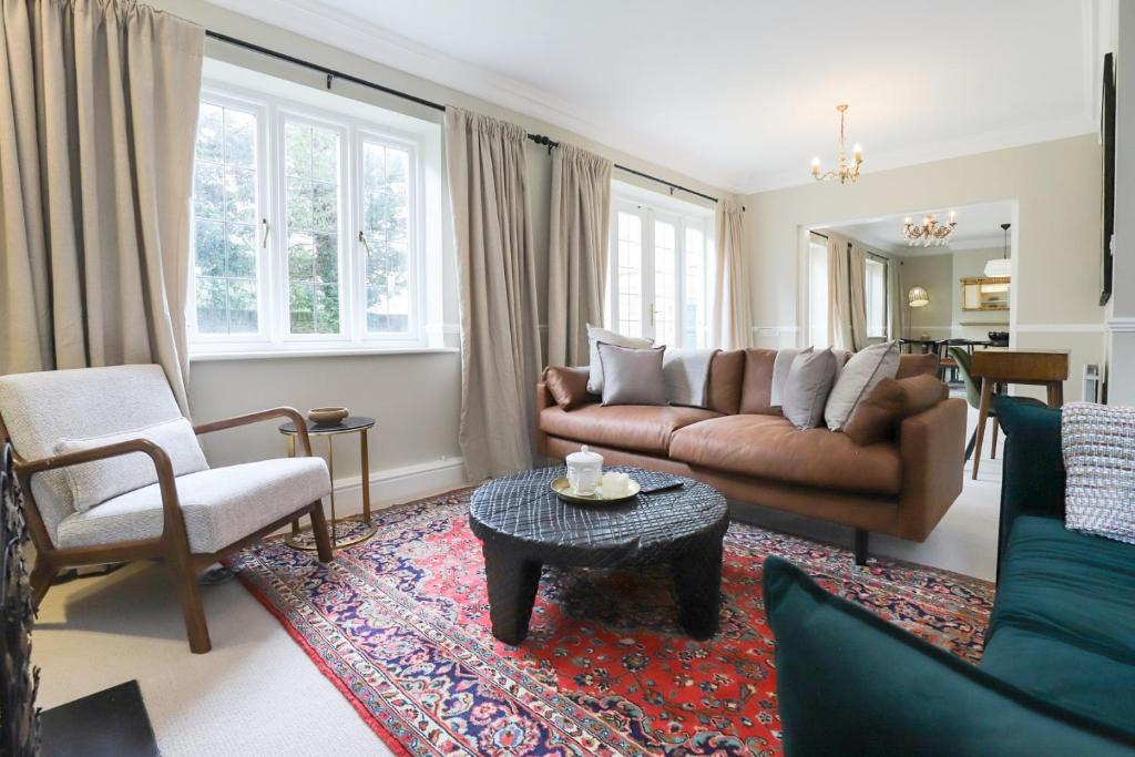 a living room with a couch and a table at The Stow Secret Cottage - Breathtaking 5BDR Cottage with Parking & Garden in Stow on the Wold