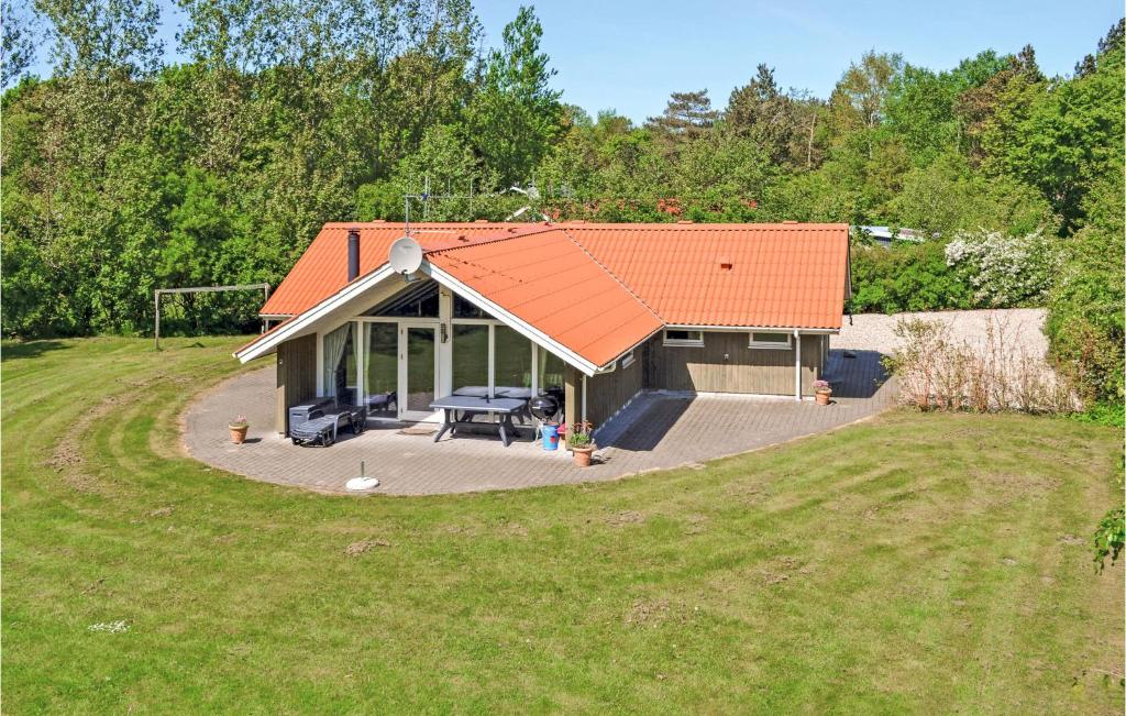 una casa con techo naranja en un campo en Awesome Home In Oksbl With Sauna, en Oksbøl