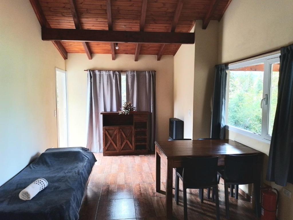 sala de estar con mesa y sofá en Aparts chalet Alquimia en Lago Puelo