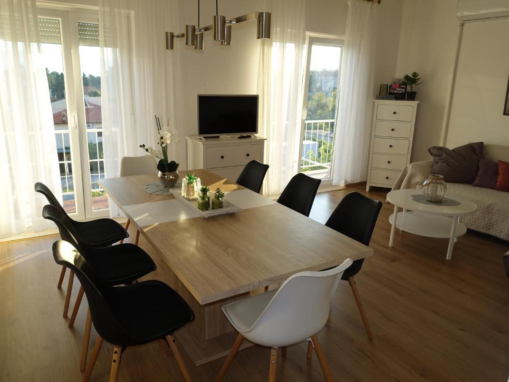 a dining room table and chairs in a living room at Klimatisiertes Apartment Barbara in Trpanj