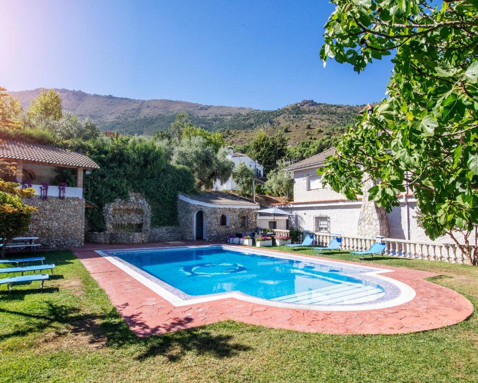 una piscina en un patio con una casa en Villa Fuji Sierra de la Pandera Jaén, en Jaén