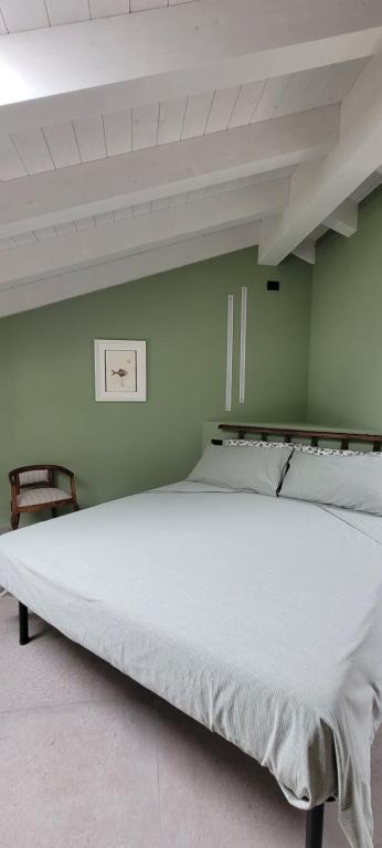 uma grande cama branca num quarto verde em La Sarmassa em Vernasca
