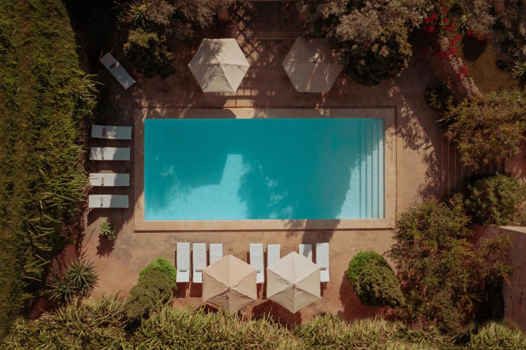 an overhead view of a swimming pool with a white fence at CASA SAN ROCCO - Luxurious Grand 18th C. Palace with Gardens & Pool in Hal Ghaxiak