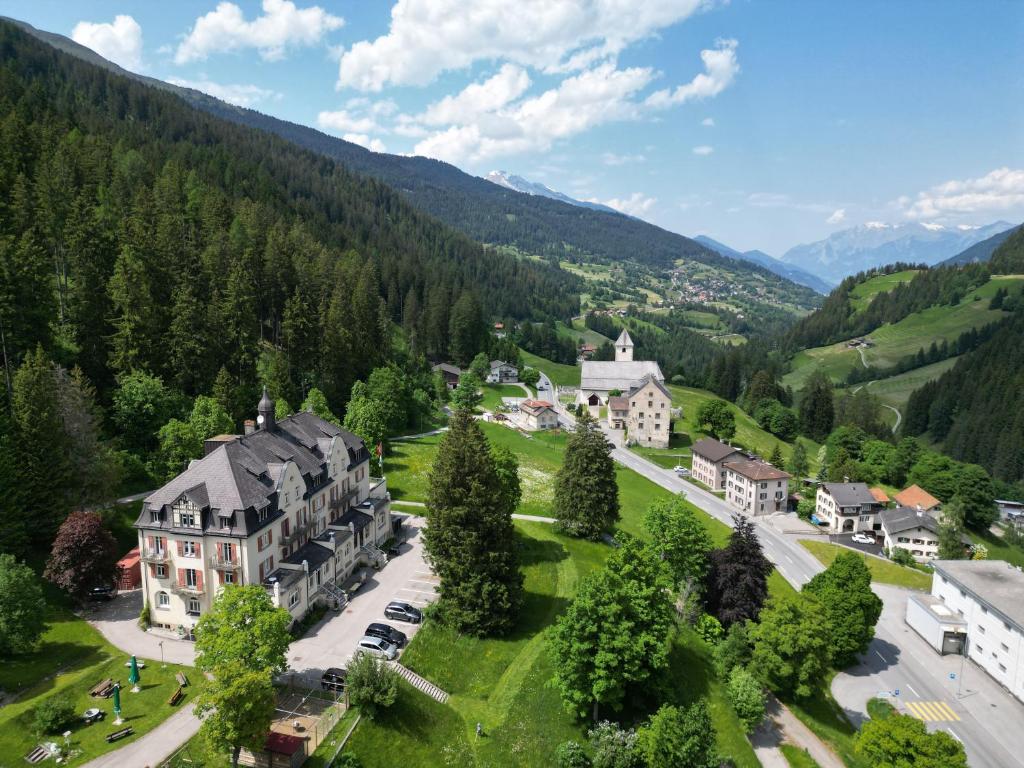 - une vue aérienne sur une grande maison dans les montagnes dans l'établissement Gruppenhaus Lindenhof Churwalden, à Churwalden