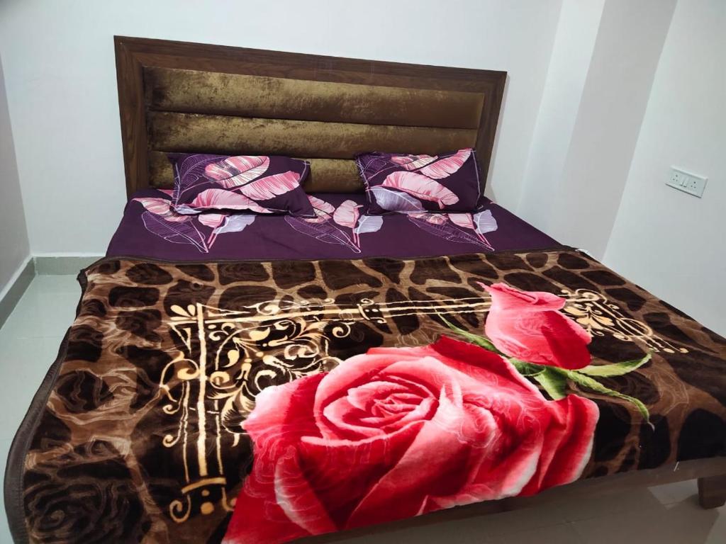a bed with a red rose on it at Deviksha Home Stay in Ujjain