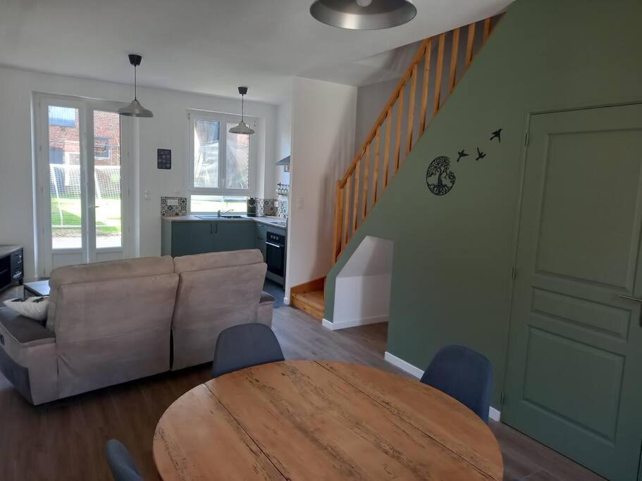 ein Wohnzimmer mit einem Tisch und einem Sofa in der Unterkunft Chez Sindy et Olivier in Crèvecoeur-le-Grand
