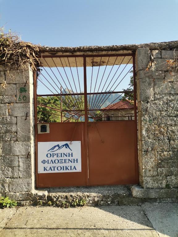 una puerta con un cartel al lado de un edificio en Ορεινή φιλόξενη κατοικια, 