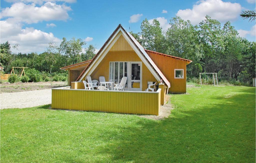 a house with a deck with white chairs on it at Nice Home In Oksbl With 3 Bedrooms, Sauna And Wifi in Oksbøl