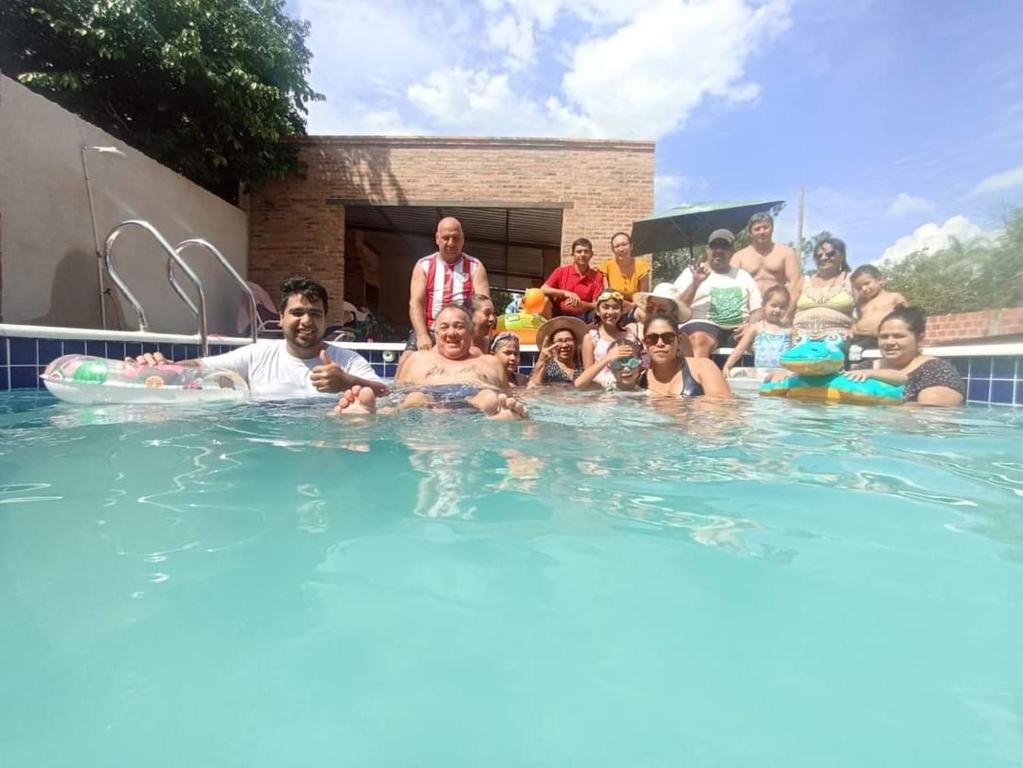 un groupe de personnes dans une piscine dans l'établissement Quinta DonAmado, à Areguá