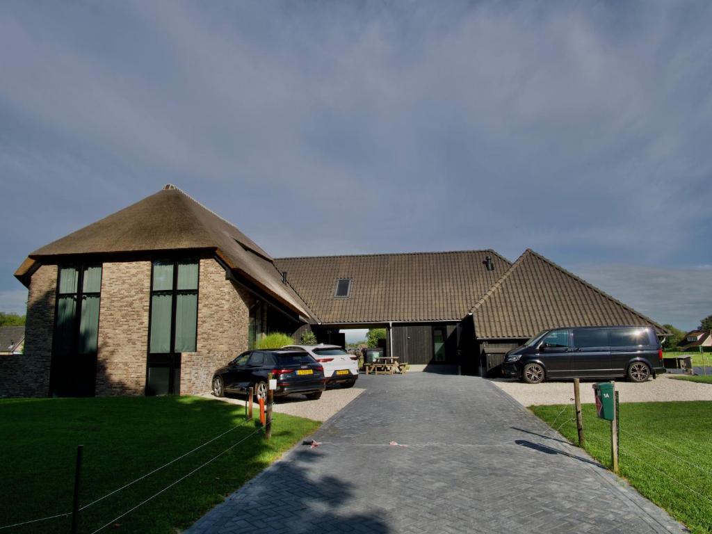 a house with cars parked in front of it at La Vita Veluwe in Wapenveld