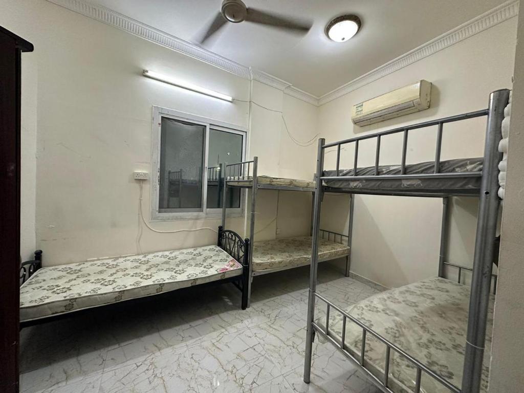 a room with three bunk beds and a window at Bed Space for Female single and bunk bed Al Sayed Builidng - Sharaf DG Exit 4 Flat 301 in Dubai