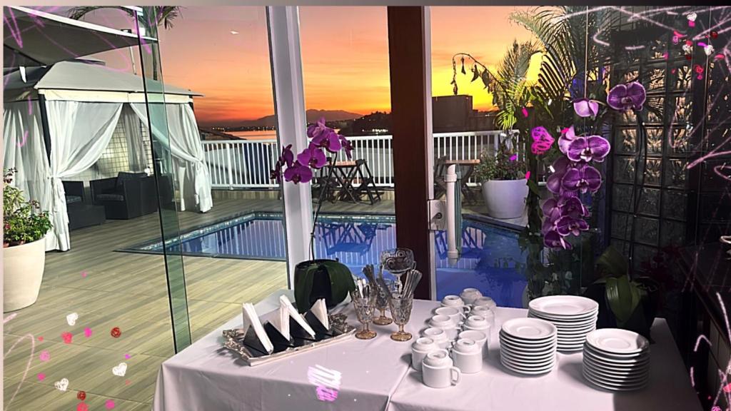 a table with plates and cups on top of a balcony at Hotel Pousada Irmaos Freyhardt in Rio de Janeiro