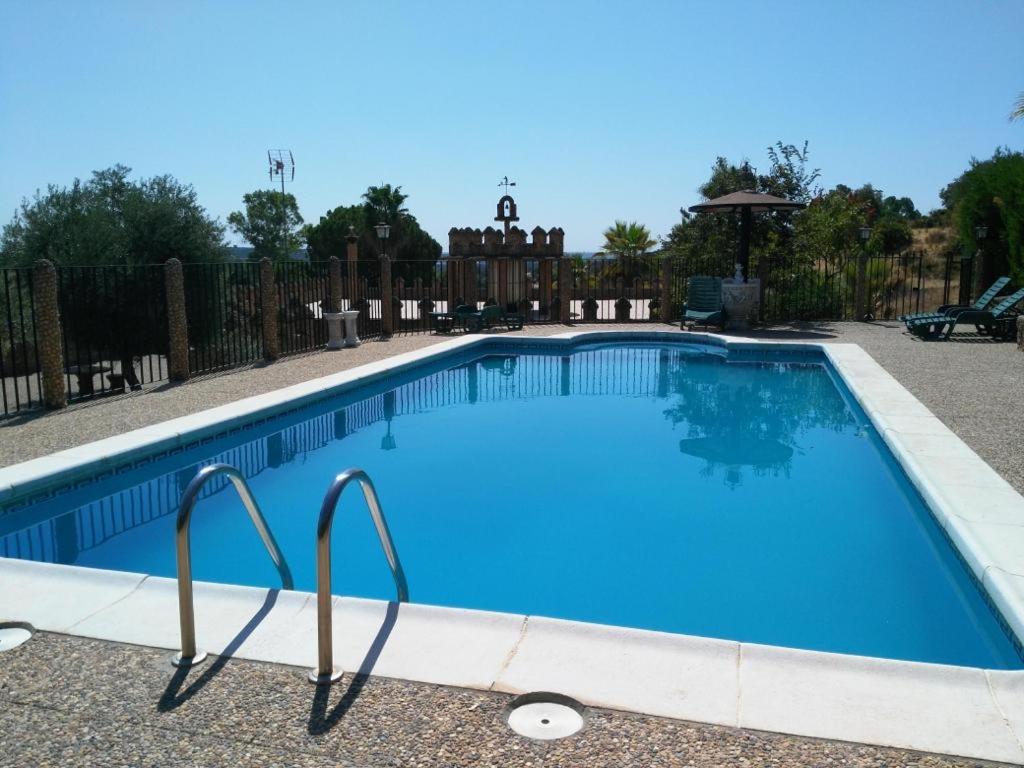 - une grande piscine d'eau bleue dans la cour dans l'établissement VFT Las Piedrecitas, à Hornachuelos