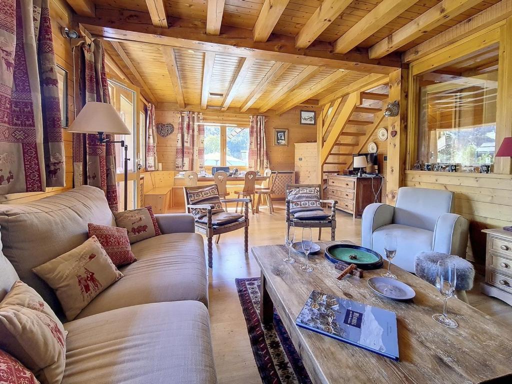 un soggiorno con un divano e un tavolo di Chalet typique ski-in/ski-out, cheminée et terrasse, parking, Wi-Fi inclus à Méribel - FR-1-688-15 a Méribel