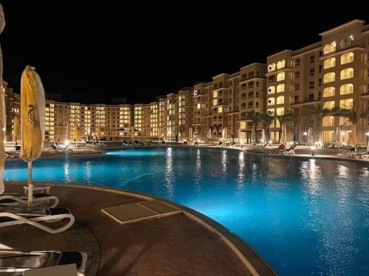 uma grande piscina num resort à noite em Unique studio- Aqua View Resort em El Alamein