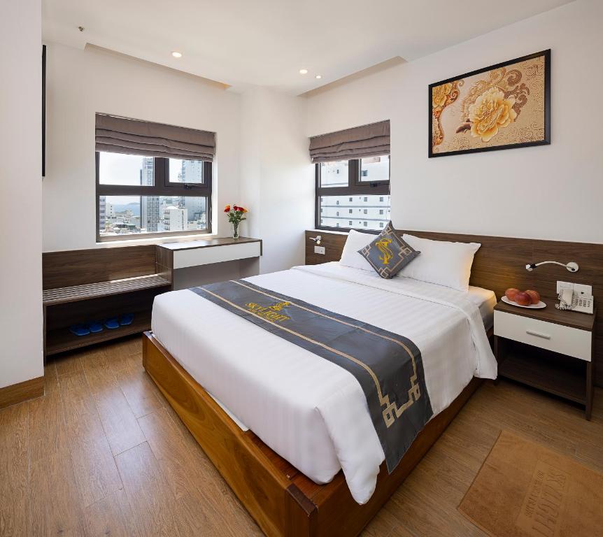 um quarto com uma cama grande e uma janela em Skylight Hotel Nha Trang em Nha Trang