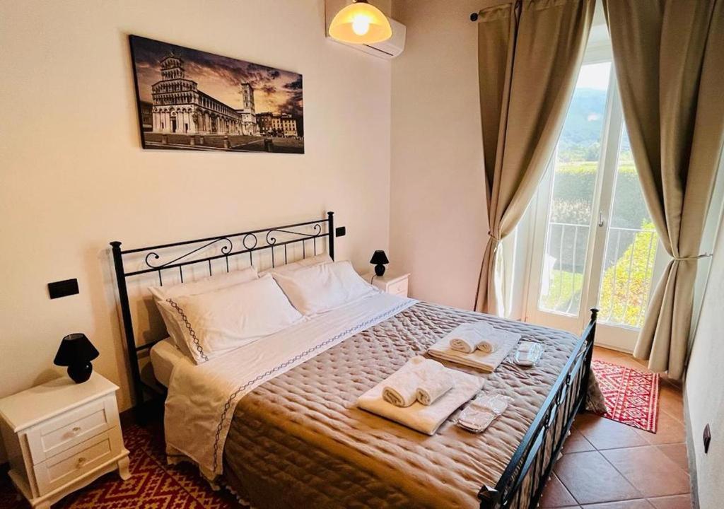 sypialnia z łóżkiem z ręcznikami i oknem w obiekcie B&B Giardino delle Camelie w mieście Capannori