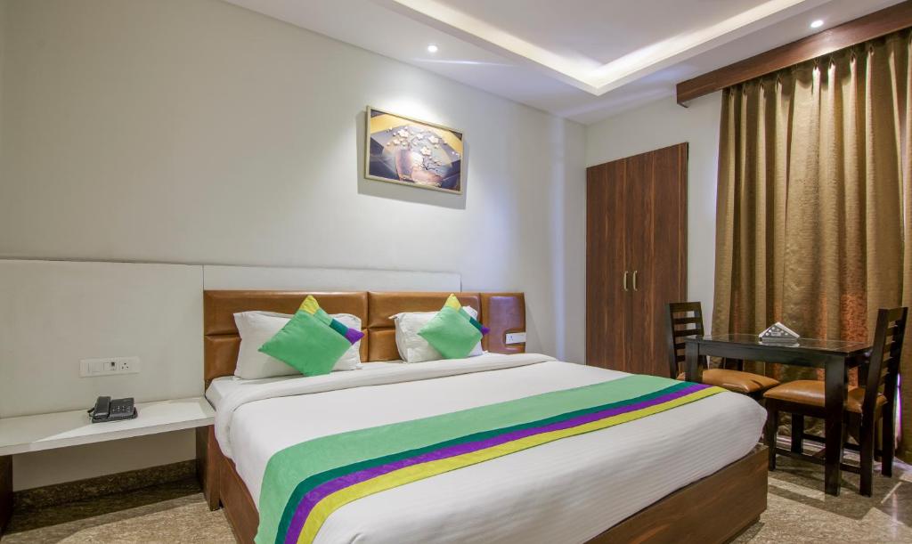 Cette chambre comprend un grand lit et un bureau. dans l'établissement Treebo Trend Swastika Premium, à Noida