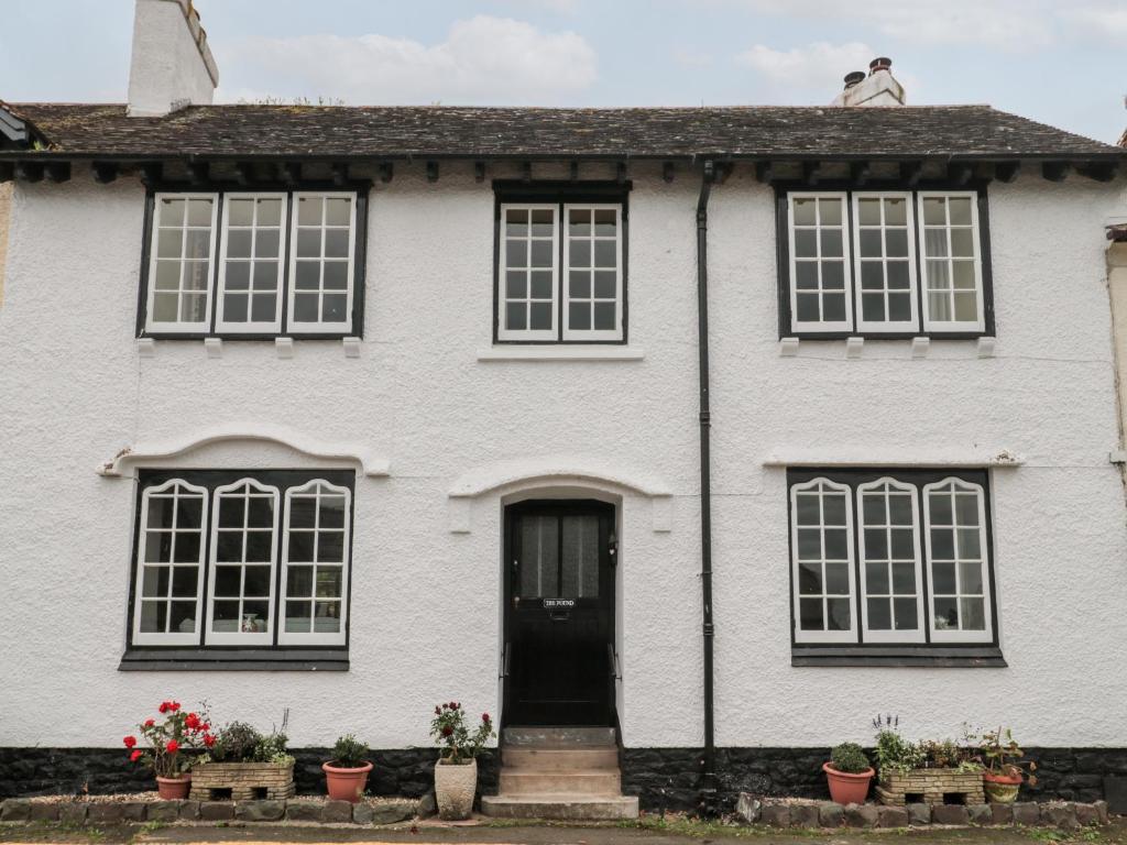 Casa blanca con puerta y ventanas negras en The Pound, en Minehead