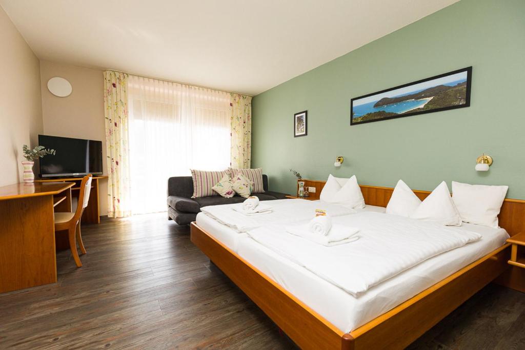a hotel room with a large bed and a couch at Landgasthaus Gieseke-Asshorn in Bohmte