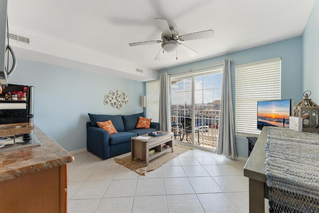 a living room with a blue couch and a tv at Nw Condo W Private Balcony & Pool in North Wildwood