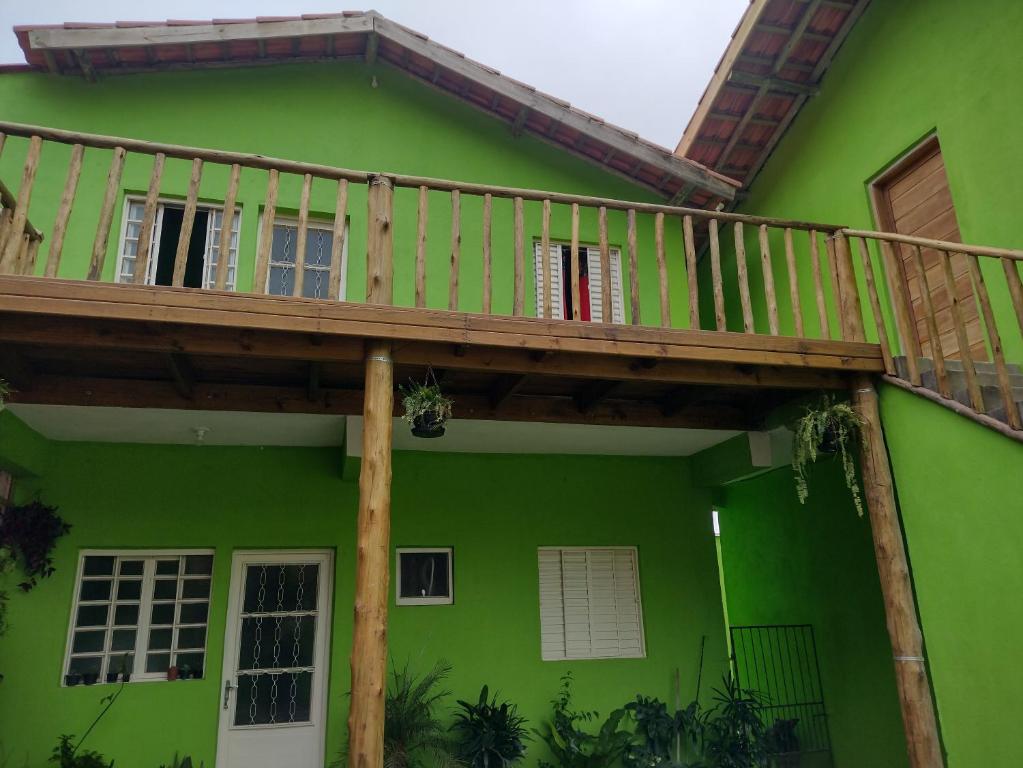 a green house with a wooden deck on top at Chale 8A in Cunha