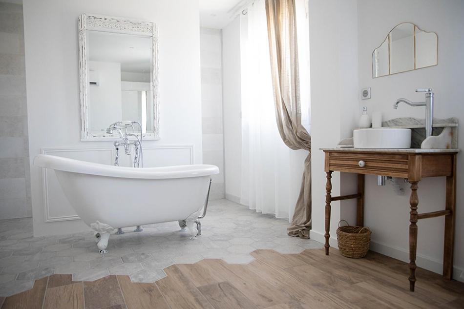 a white bathroom with a tub and a mirror at Superbe appartement - L'escapade in Onzain