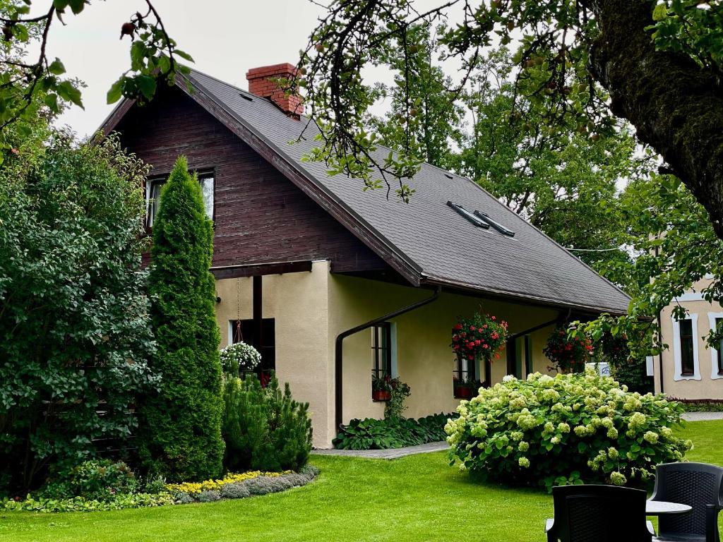 uma casa com um jardim verde em frente em Hostel Livonija em Sigulda