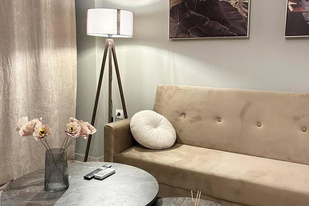 a living room with a couch and a table and a lamp at yourcomfortzone*VOLOS in Volos