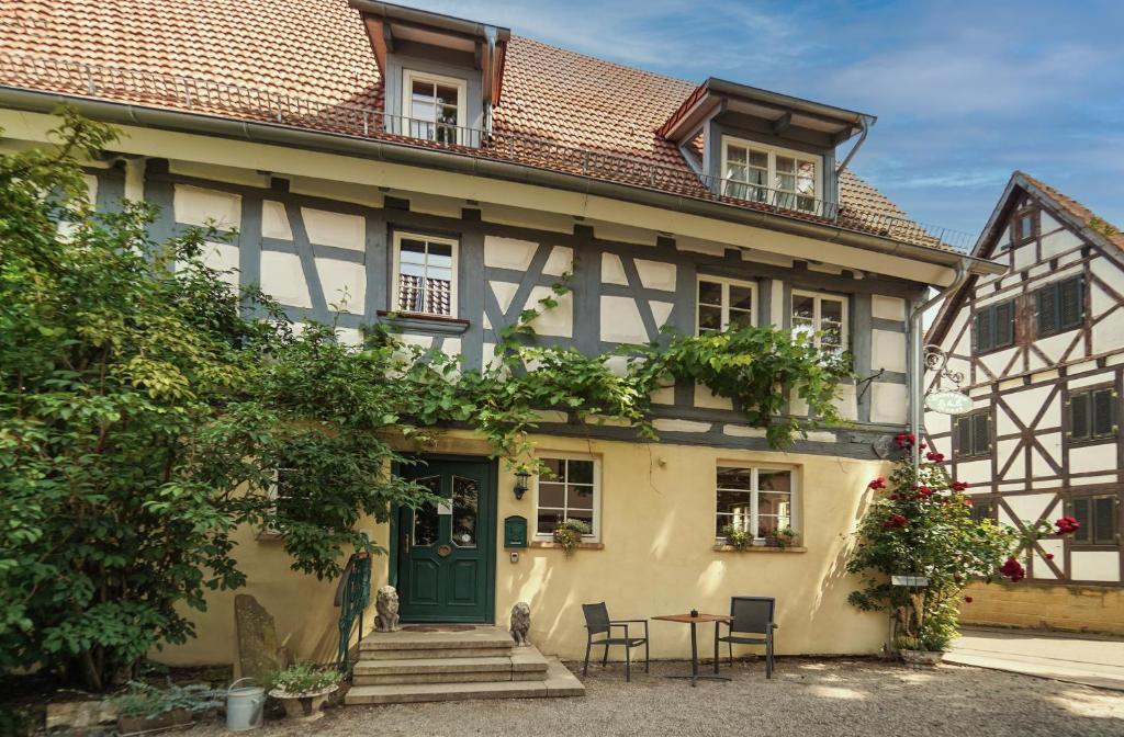 una casa antigua con una puerta verde y sillas en Stevenson House Bed and Breakfast, en Oberderdingen