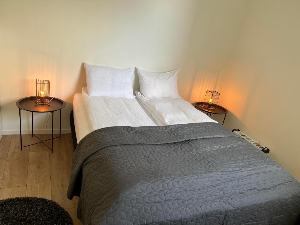 a bedroom with a large bed with two tables at Hellegata 7 in Ålesund