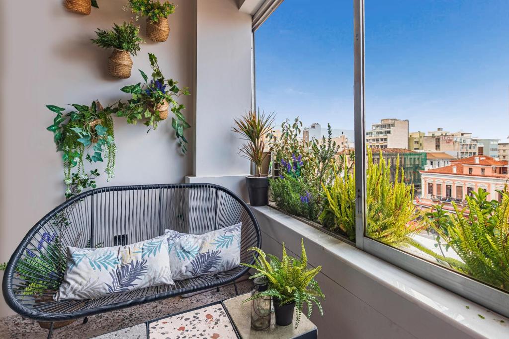 een balkon met een bank en potplanten bij Hidesign Athens The Getaway Apartments in Athene