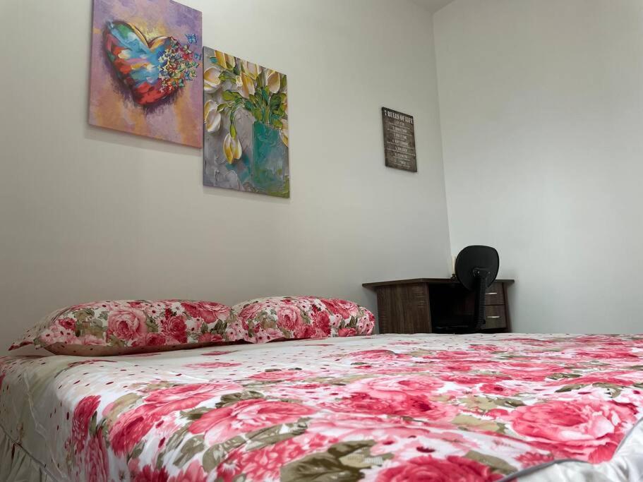 a bedroom with a bed with a red flowered blanket at Gembira Alanis by H Family #KLIA #Wifi #Netflix in Sepang