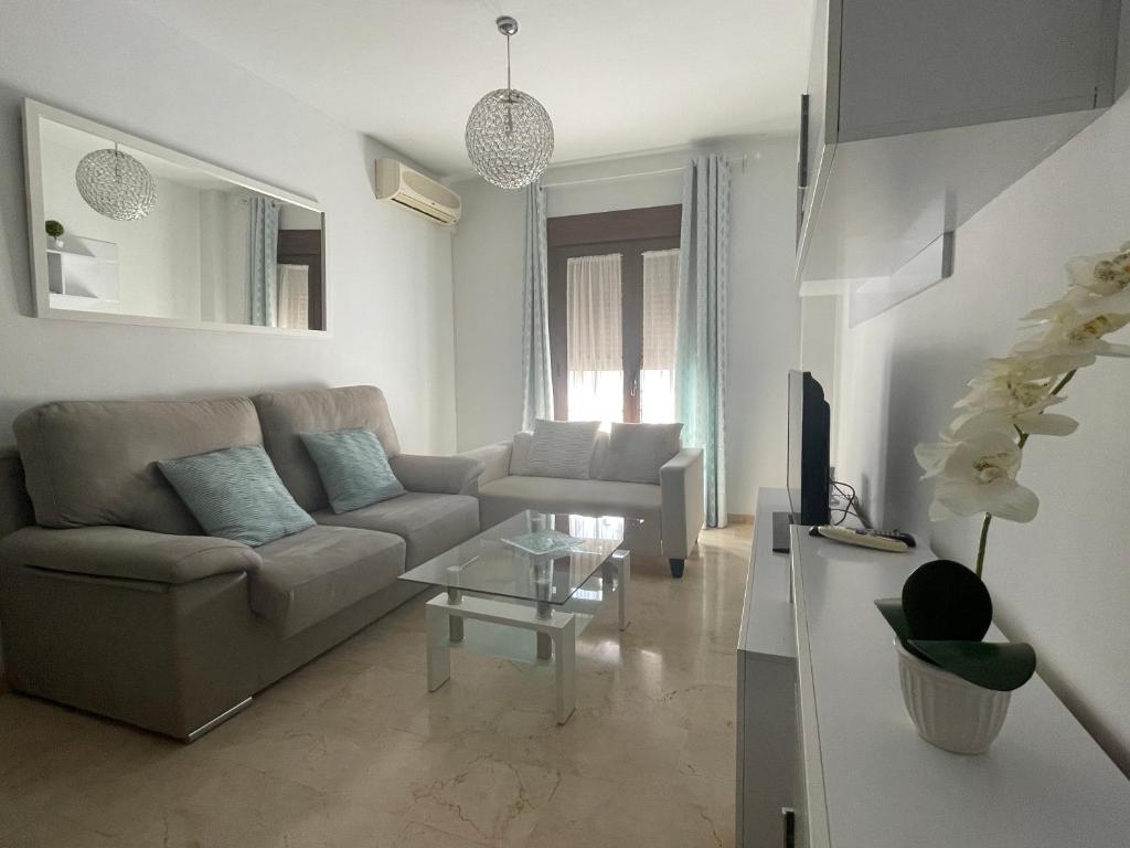 een woonkamer met een bank en een tafel bij Apartamento Alameda del Tajo III Centro Parquing in Ronda