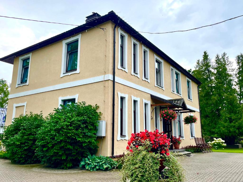 ein großes Haus mit Blumen davor in der Unterkunft Livonija in Sigulda