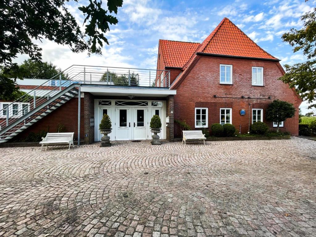 a brick house with two benches in front of it at Pidder Lüng in Bargum