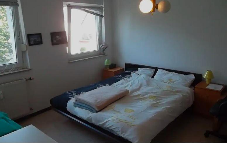 un grande letto in una camera da letto con finestra di Düsseldorf - separates, privates Zimmer a Dusseldorf