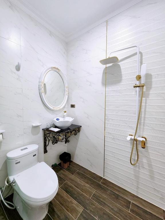 a bathroom with a toilet and a sink and a mirror at Paris Hotel & Cafe in Vĩnh Long