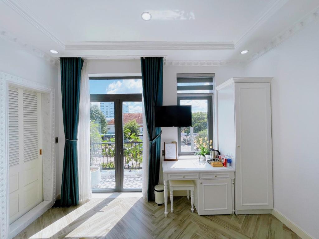 a white room with a desk and a window at Paris Hotel & Cafe in Vĩnh Long