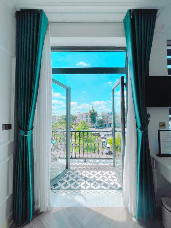 a room with a door open to a balcony at Paris Hotel & Cafe in Vĩnh Long