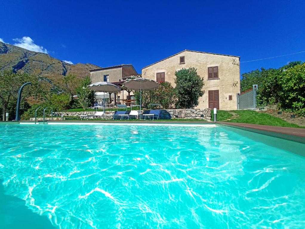 uma piscina de água azul em frente a uma casa em Casa del Sole em Polizzi Generosa