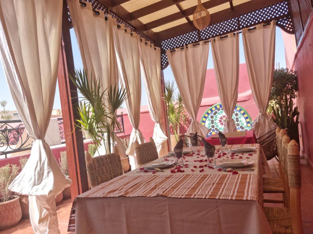 a table on a balcony with curtains and a tableablish at Riad La Bigarade in Marrakesh