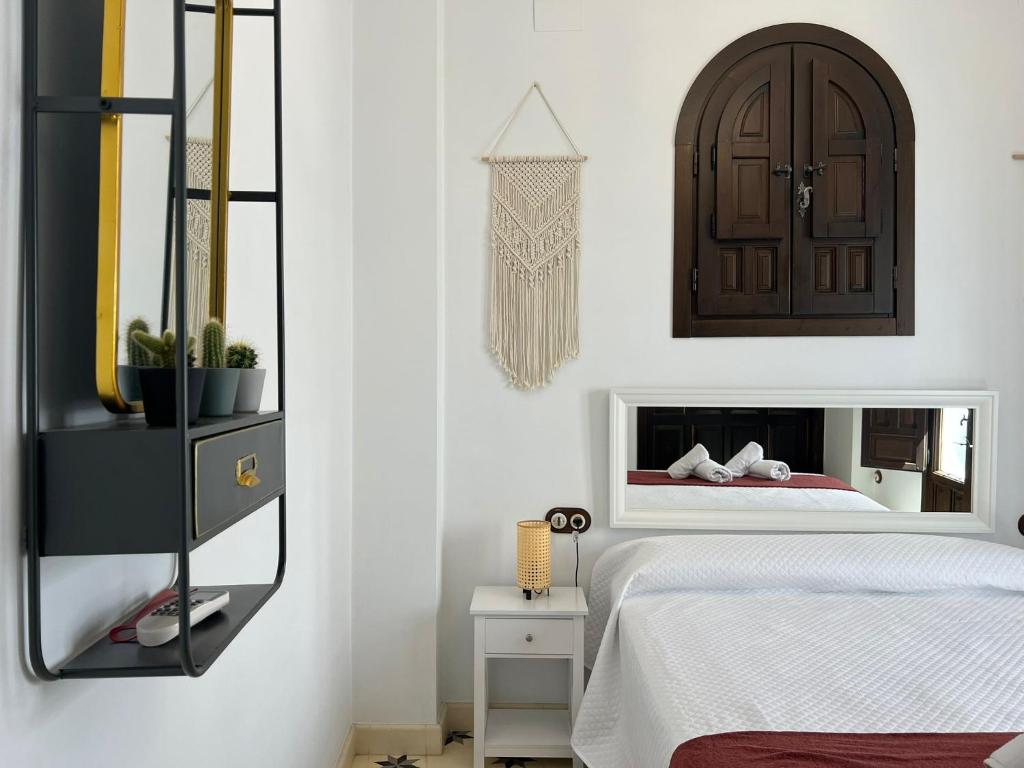 ein Schlafzimmer mit einem Bett und einem Spiegel an der Wand in der Unterkunft Casa Remanso de la Judería in Córdoba