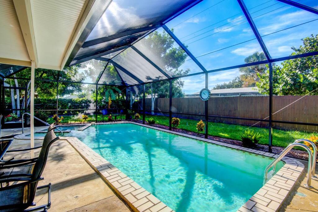 uma piscina numa casa com uma casa de vidro em Close to Siesta Key, Shopping, Restaurants & More! em Sarasota