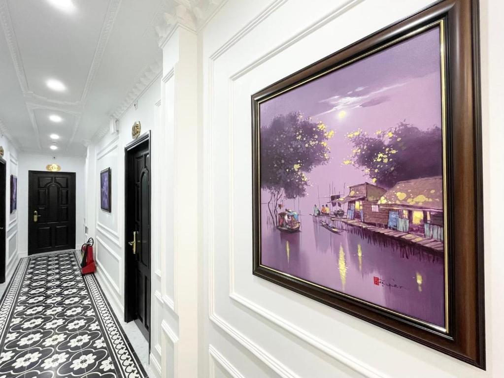 a large painting on the wall in a hallway at Paris Hotel & Cafe in Vĩnh Long