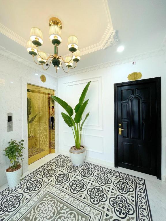 a room with a black door and a potted plant at Paris Hotel & Cafe in Vĩnh Long